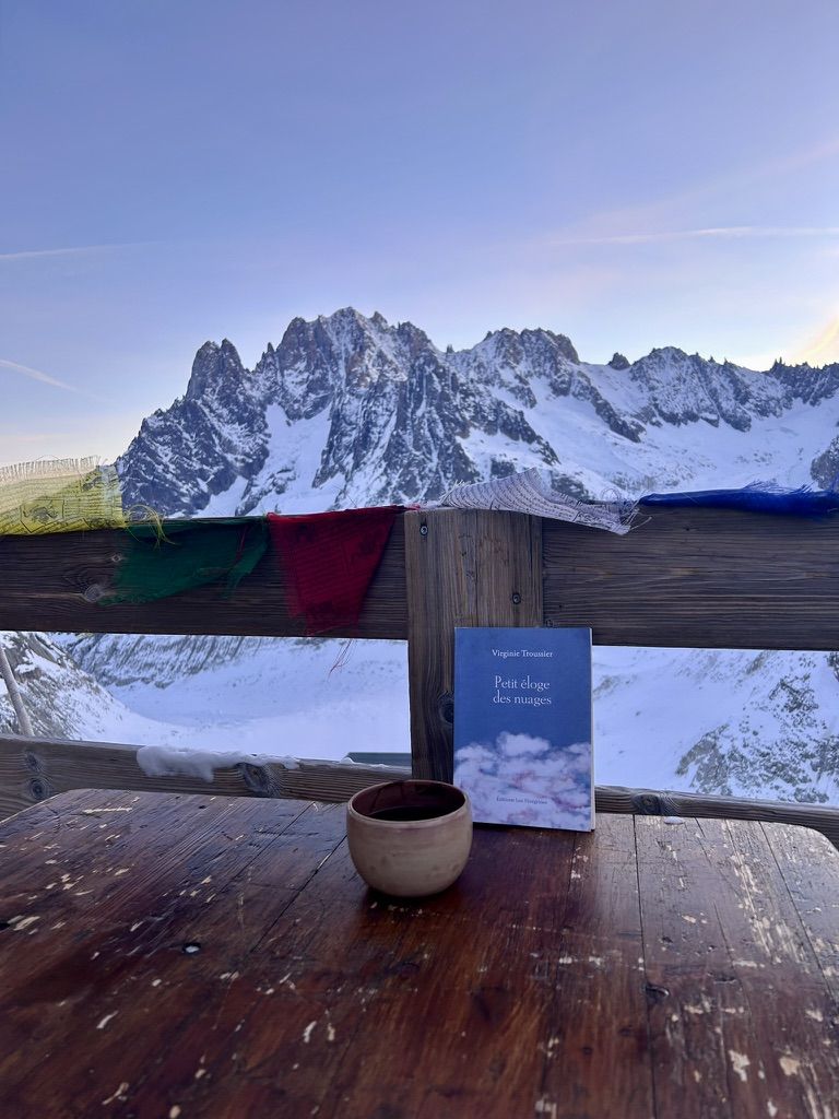 Une tasse et un livre sur la terrasse au lever du jour